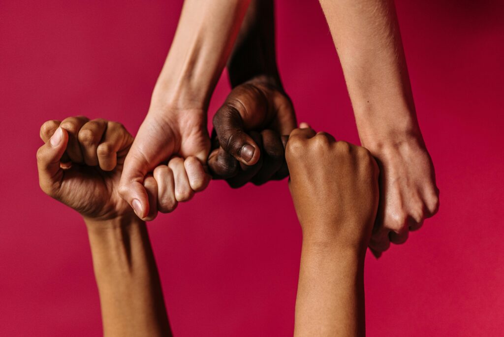 pexels-photo-9486934-9486934 Diverse hands showing unity against a vibrant pink background, symbolizing harmony.